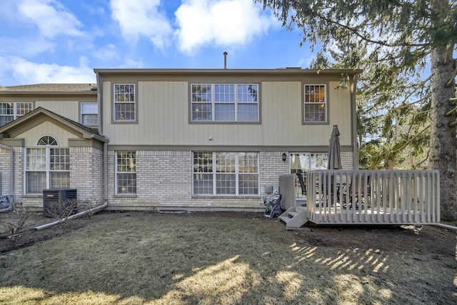 back of property with a deck, central air condition unit, and brick siding