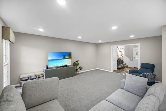 carpeted living area with recessed lighting, stairway, and baseboards