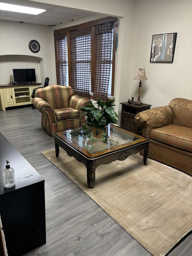 living room featuring a paneled ceiling and wood-type flooring