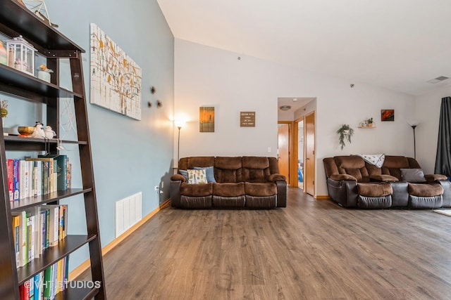 living room with hardwood / wood-style flooring and vaulted ceiling