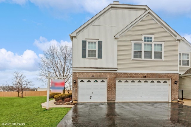 view of front of property with an attached garage, brick siding, fence, driveway, and a front yard