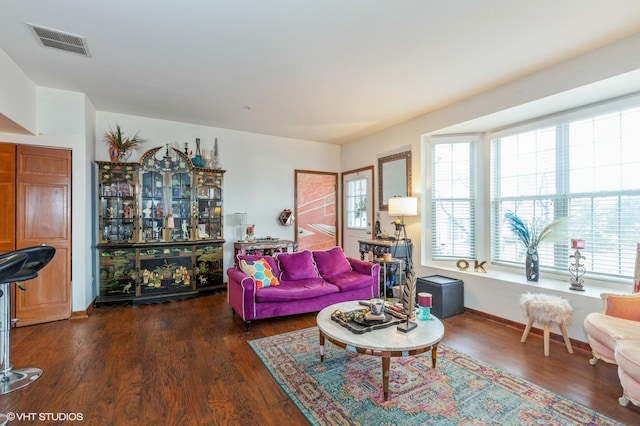 living area with dark wood-style floors, visible vents, and baseboards