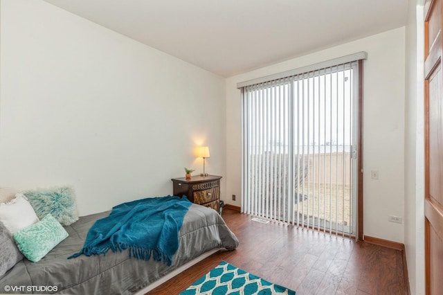 bedroom with access to outside, baseboards, and wood finished floors