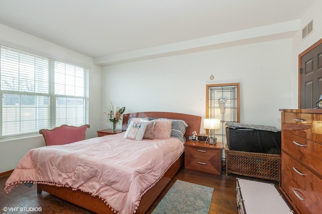 bedroom with dark wood-style floors and visible vents