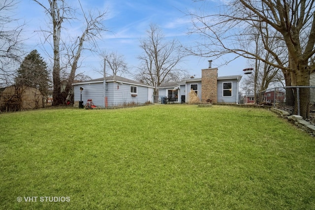 rear view of house featuring a yard