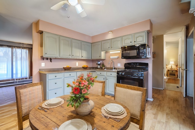 kitchen featuring ceiling fan, sink, light hardwood / wood-style floors, and black appliances