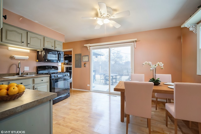 kitchen with ceiling fan, electric panel, black appliances, green cabinetry, and light wood-type flooring