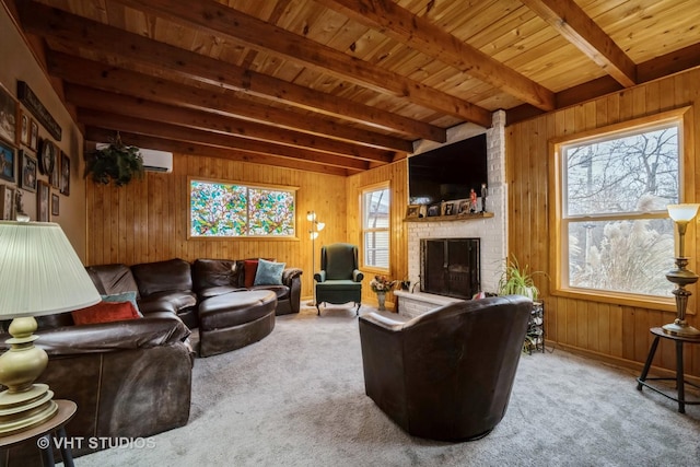 living room with beamed ceiling, carpet floors, a brick fireplace, and wood walls