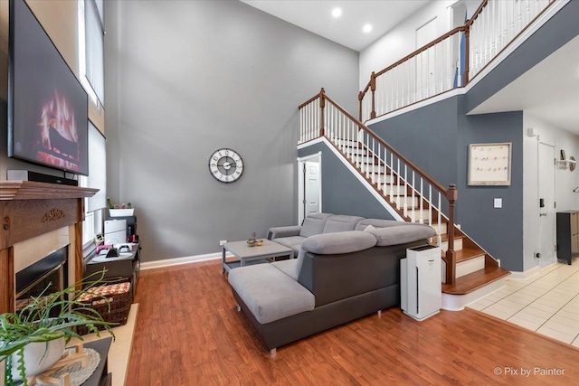 living room with hardwood / wood-style floors and a towering ceiling