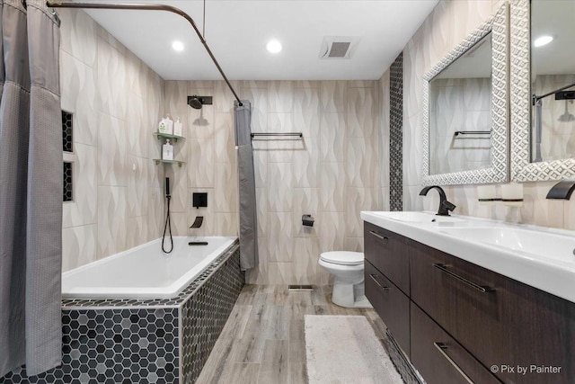 full bathroom featuring toilet, wood-type flooring, tile walls, vanity, and shower / bath combination with curtain