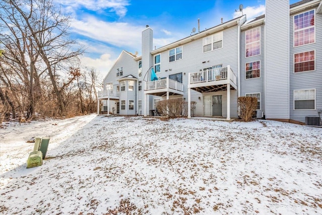 snow covered property featuring central AC