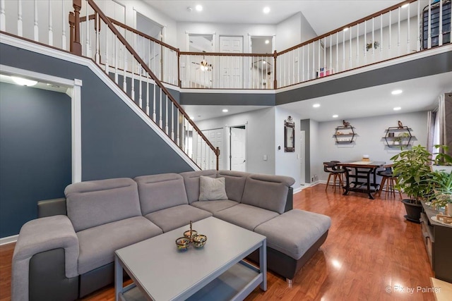 living room featuring a towering ceiling and wood-type flooring