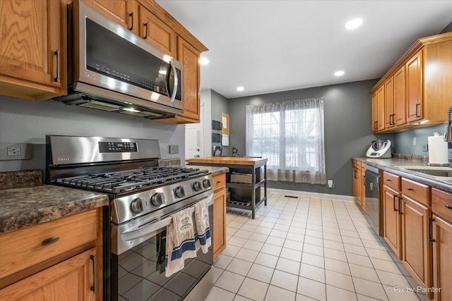 kitchen featuring light tile patterned floors, stainless steel appliances, and sink