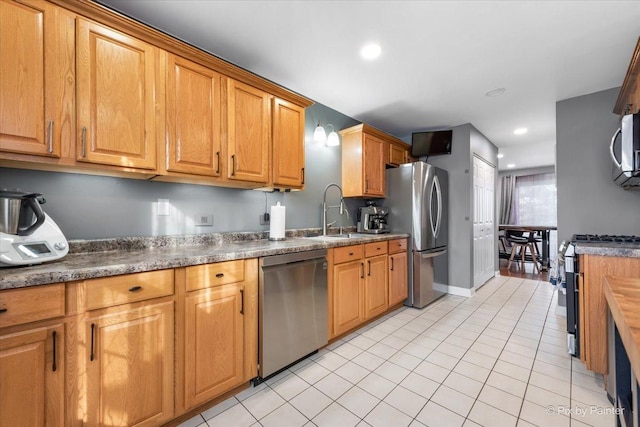 kitchen featuring stainless steel appliances, sink, and light tile patterned floors