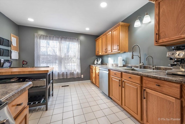 kitchen featuring sink, stainless steel dishwasher, and light tile patterned floors