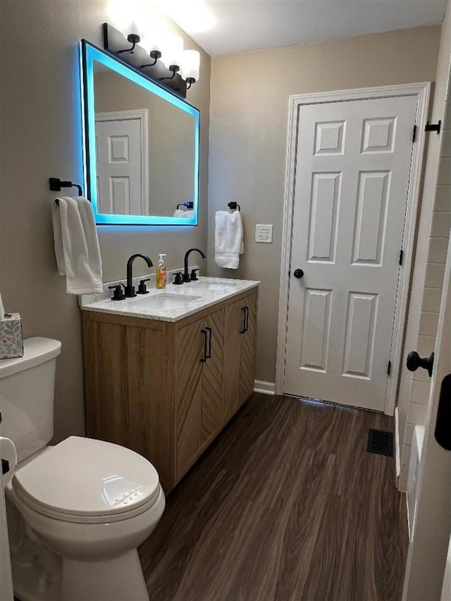 bathroom featuring vanity, toilet, and wood finished floors