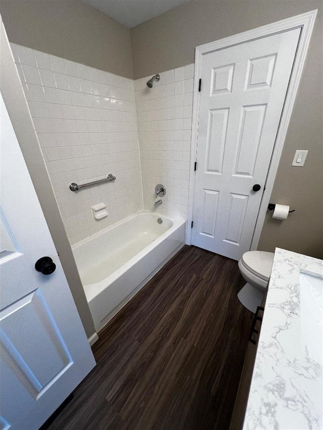 full bath featuring toilet, shower / washtub combination, wood finished floors, and vanity