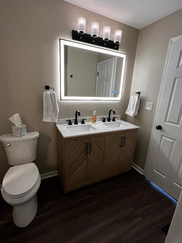 bathroom featuring wood finished floors, a sink, and toilet