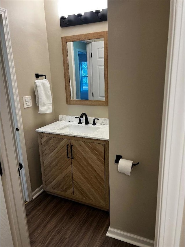 bathroom featuring wood finished floors, vanity, and baseboards