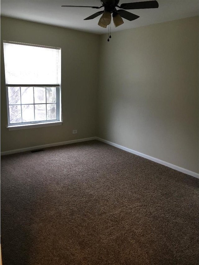 carpeted spare room featuring ceiling fan