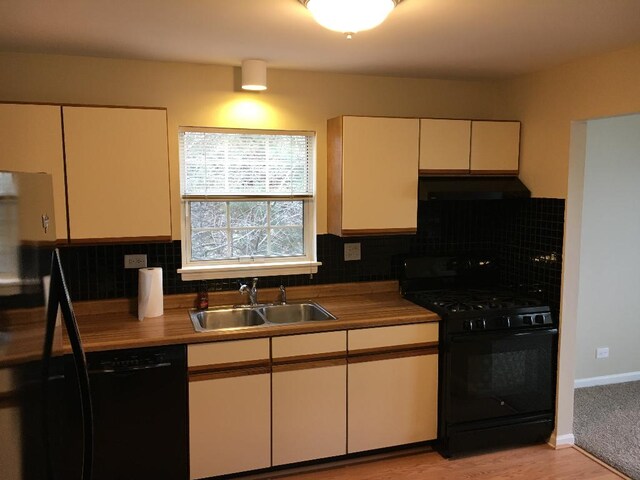 kitchen featuring ventilation hood, tasteful backsplash, sink, and black appliances