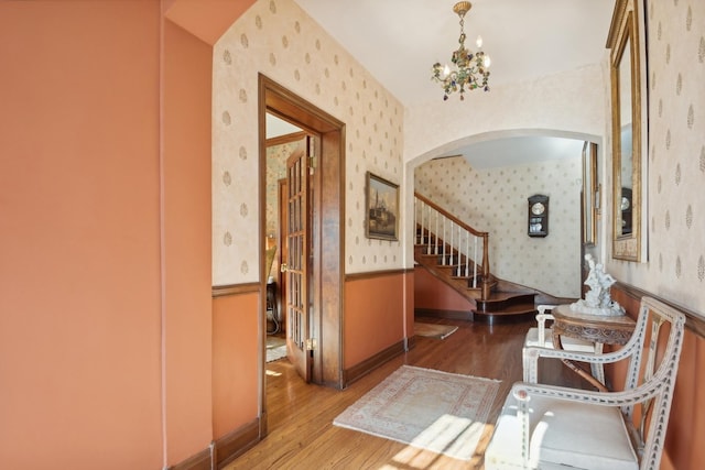 hallway with dark hardwood / wood-style flooring and a notable chandelier