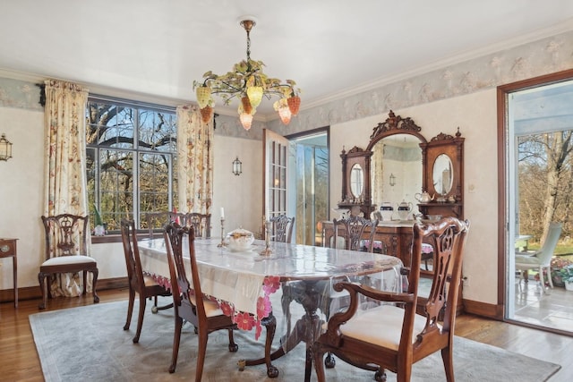 dining space with crown molding, hardwood / wood-style floors, and a notable chandelier