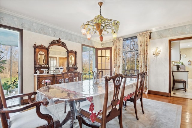 dining room with crown molding, a wealth of natural light, and light hardwood / wood-style floors