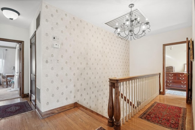 hallway featuring an inviting chandelier and wood-type flooring