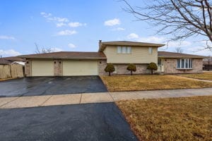 tri-level home with a garage and a front lawn