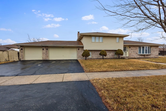 tri-level home with a garage and a front yard