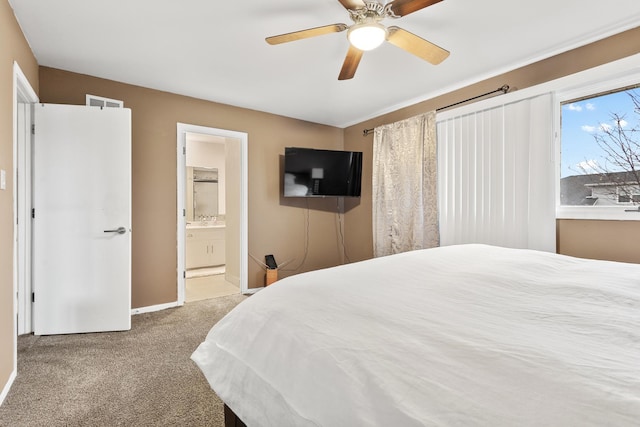 carpeted bedroom featuring ceiling fan and ensuite bath