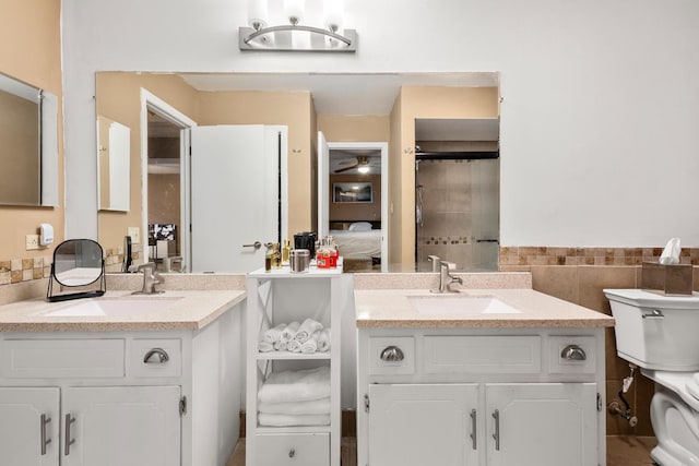 bathroom with tile walls, vanity, toilet, and ceiling fan