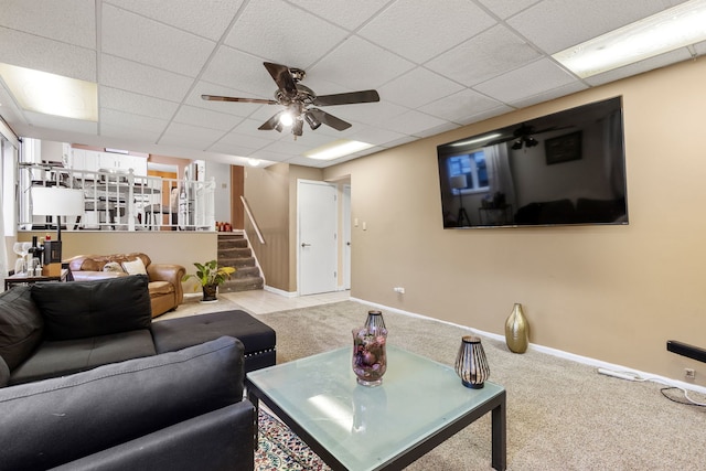 carpeted living room featuring ceiling fan and a drop ceiling