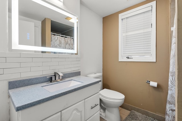 bathroom featuring tile patterned floors, vanity, toilet, and decorative backsplash