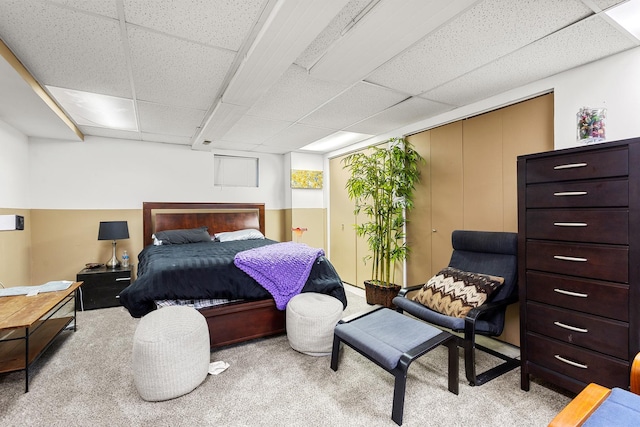 bedroom with light carpet, a paneled ceiling, and access to outside