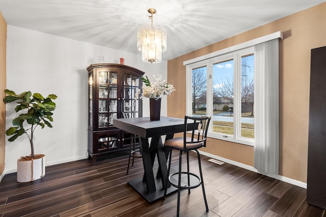 dining room featuring dark hardwood / wood-style flooring and a notable chandelier