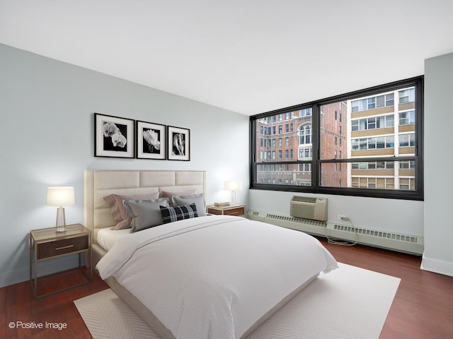 bedroom with a wall unit AC, dark hardwood / wood-style flooring, and baseboard heating