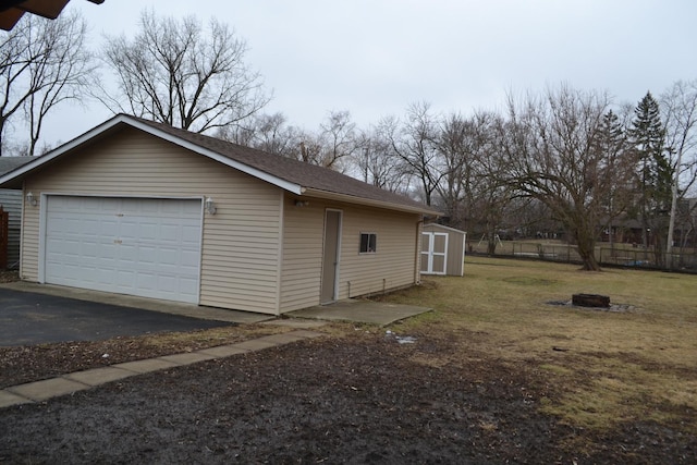 view of property exterior featuring a garage, an outdoor fire pit, and a storage unit