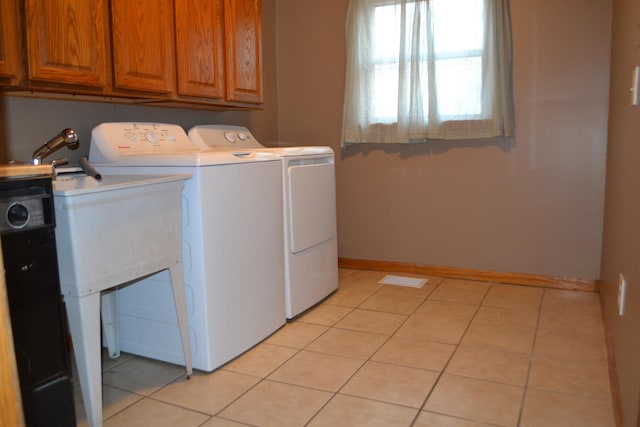 washroom with independent washer and dryer and light tile patterned floors