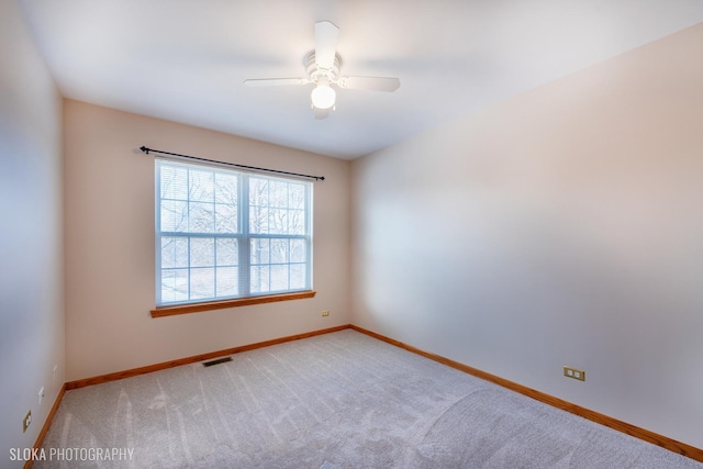 empty room featuring ceiling fan and light carpet