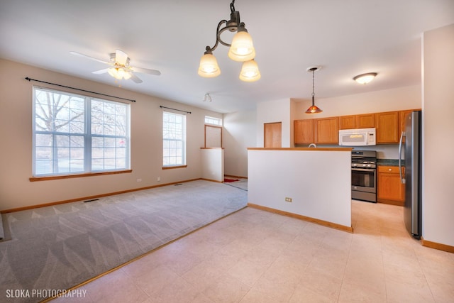 kitchen with ceiling fan, appliances with stainless steel finishes, light colored carpet, and hanging light fixtures