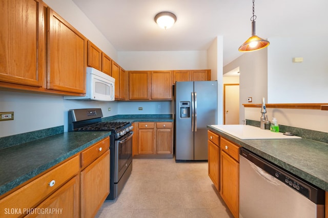 kitchen featuring hanging light fixtures, appliances with stainless steel finishes, and sink