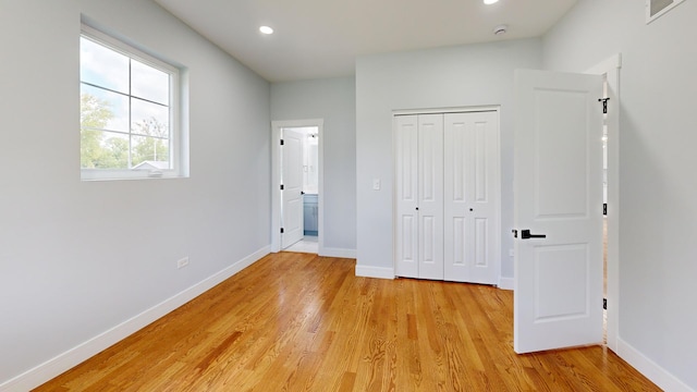 unfurnished bedroom featuring light hardwood / wood-style floors and a closet