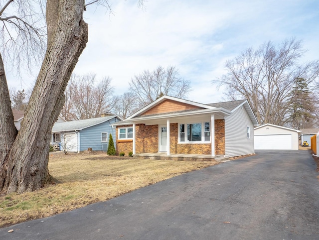 single story home featuring a garage, an outdoor structure, and a front yard