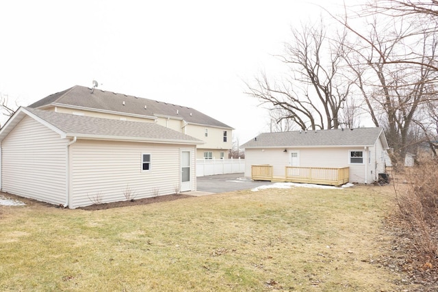 rear view of property featuring a yard and a deck