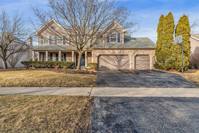 view of front property with a garage, a front lawn, and a porch