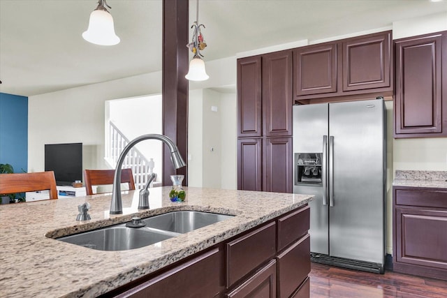 kitchen featuring dark wood-type flooring, hanging light fixtures, a sink, and stainless steel refrigerator with ice dispenser