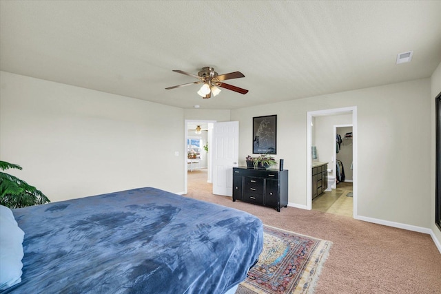 bedroom featuring baseboards, a textured ceiling, visible vents, and light colored carpet