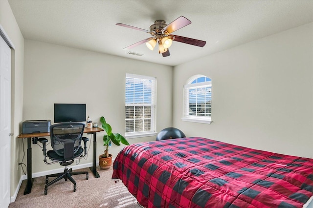 carpeted bedroom featuring a ceiling fan, a closet, visible vents, and baseboards